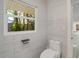 Bright bathroom featuring a toilet and window with views of palm trees at 115 N Blvd Of The Presidents, Sarasota, FL 34236