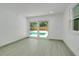 Bright bedroom with sliding glass doors leading to a pool and light colored flooring at 115 N Blvd Of The Presidents, Sarasota, FL 34236