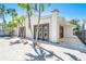Beautiful home with a light-colored facade and a tiled walkway, framed by lush palms and a serene blue sky at 115 N Blvd Of The Presidents, Sarasota, FL 34236