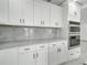 Modern kitchen with white cabinets, stainless steel appliances, and light wood floors at 115 N Blvd Of The Presidents, Sarasota, FL 34236
