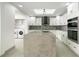 Large, modern kitchen with island, stainless steel appliances and a convenient adjacent laundry area at 115 N Blvd Of The Presidents, Sarasota, FL 34236