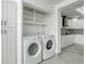 Clean laundry room with white washer and dryer, complemented by white cabinets at 115 N Blvd Of The Presidents, Sarasota, FL 34236