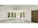 Inviting living room with white walls, light wood floors, and natural light pouring in from four windows at 115 N Blvd Of The Presidents, Sarasota, FL 34236