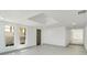 Bright living room with white walls, recessed lighting, a large skylight, light wood floors, and a dark brown door at 115 N Blvd Of The Presidents, Sarasota, FL 34236