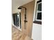 Inviting outdoor shower featuring sleek black fixtures and stylish wood-look paneling next to sliding glass doors at 115 N Blvd Of The Presidents, Sarasota, FL 34236