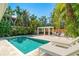 Backyard with sparkling pool, stylish pergola, and comfortable lounge area surrounded by palm trees at 115 N Blvd Of The Presidents, Sarasota, FL 34236