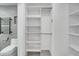 Organized walk-in closet with built-in shelving and rods, offering ample storage space with a toilet to the left at 115 N Blvd Of The Presidents, Sarasota, FL 34236