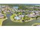 An aerial view of a community lake with a community pool and clubhouse, surrounded by numerous houses and lush landscaping at 2640 Suncoast Lakes Blvd, Punta Gorda, FL 33980