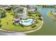 An aerial view of a resort-style community pool and clubhouse on the shores of a lake surrounded by palm trees at 2640 Suncoast Lakes Blvd, Punta Gorda, FL 33980