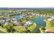 An aerial view of a resort-style community pool with a lake, lush landscaping, and surrounding homes at 2640 Suncoast Lakes Blvd, Punta Gorda, FL 33980