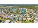 An elevated view displays community homes nestled around a picturesque lake and trees at 2640 Suncoast Lakes Blvd, Punta Gorda, FL 33980