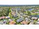 An aerial view capturing houses surrounding a picturesque lake and mature trees at 2640 Suncoast Lakes Blvd, Punta Gorda, FL 33980