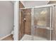 Bathroom shower featuring a tiled shower stall with glass doors and neutral-toned tile and a shower head at 2640 Suncoast Lakes Blvd, Punta Gorda, FL 33980