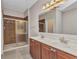 Bathroom featuring a large vanity with double sinks and a walk-in shower with tile surround at 2640 Suncoast Lakes Blvd, Punta Gorda, FL 33980