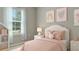 Charming bedroom with plush pink bedding, a sunny window, and playful wall art at 2640 Suncoast Lakes Blvd, Punta Gorda, FL 33980