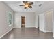 Spacious bedroom features wood-look tile floors, ceiling fan, and ample natural light from the window at 2640 Suncoast Lakes Blvd, Punta Gorda, FL 33980