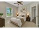 Cozy bedroom with neutral decor, comfortable bed, and windows offering views of lush greenery at 2640 Suncoast Lakes Blvd, Punta Gorda, FL 33980