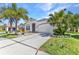 Charming single-story home boasting a well-manicured lawn, lush palm trees, and a welcoming two-car garage at 2640 Suncoast Lakes Blvd, Punta Gorda, FL 33980
