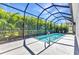 Backyard view of a private screened-in pool surrounded by lush palm trees at 2640 Suncoast Lakes Blvd, Punta Gorda, FL 33980