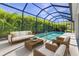 Screened-in pool featuring cozy seating with palm tree views and blue skies at 2640 Suncoast Lakes Blvd, Punta Gorda, FL 33980