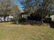 The lush backyard boasts mature trees and greenery, with a screened-in patio for serene outdoor living at 675 Hartford Heights St, Spring Hill, FL 34609