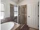 Bathroom featuring a large soaking tub, tiled surround, and walk-in shower at 675 Hartford Heights St, Spring Hill, FL 34609