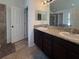 Bathroom featuring double vanity, granite countertop and a walk-in shower and door at 675 Hartford Heights St, Spring Hill, FL 34609
