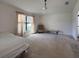 Spacious bedroom with a large window and neutral carpet and light-colored walls at 675 Hartford Heights St, Spring Hill, FL 34609