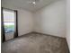 Bright bedroom with neutral carpet, a ceiling fan, and a large window with a pleasant view of the outside at 675 Hartford Heights St, Spring Hill, FL 34609