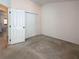 This bedroom features neutral carpet, a double closet, and a door to an adjacent room, perfect for relaxation at 675 Hartford Heights St, Spring Hill, FL 34609