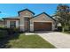 Charming home with a well-maintained lawn, a two-car garage, and mature landscaping at 675 Hartford Heights St, Spring Hill, FL 34609