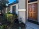 Close-up of front door showing lovely landscaping, a decorative welcome sign, and a dark mat at 675 Hartford Heights St, Spring Hill, FL 34609