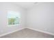 A bright bedroom with a large window providing natural light, neutral walls, and tile floors at 14552 Skipping Stone Loop, Parrish, FL 34219