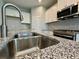 Modern kitchen with white cabinets, granite countertops, stainless steel appliances, and tile flooring at 14552 Skipping Stone Loop, Parrish, FL 34219