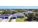 Aerial view showcasing the modern facade with a well-manicured lawn, grey roof, and dark garage door at 159 Antilla Dr, Rotonda West, FL 33947