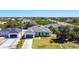 An aerial shows several homes on a street, highlighting landscaping and the home's architecture at 159 Antilla Dr, Rotonda West, FL 33947