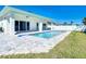 Backyard featuring a modern private pool, white fence, and green lawn at 159 Antilla Dr, Rotonda West, FL 33947