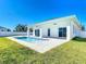 Backyard featuring a modern private pool, white fence, and green lawn at 159 Antilla Dr, Rotonda West, FL 33947