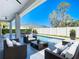 An inviting backyard oasis, with modern patio furniture and a sparkling pool, all enclosed by a crisp white fence at 159 Antilla Dr, Rotonda West, FL 33947