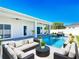 Relaxing backyard with a sparkling blue pool, comfortable patio seating, and lush landscaping for serene outdoor living at 159 Antilla Dr, Rotonda West, FL 33947