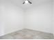 Unfurnished bedroom with neutral tile flooring, ceiling fan and white walls at 159 Antilla Dr, Rotonda West, FL 33947
