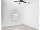 This modern bedroom features gray tile floor, a window, and ceiling fan at 159 Antilla Dr, Rotonda West, FL 33947