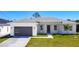 A lovely single-story home boasts a neat lawn and attractive modern garage door at 159 Antilla Dr, Rotonda West, FL 33947