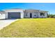 Charming one-story home with a gray roof, a two-car garage, and a well-manicured front lawn at 159 Antilla Dr, Rotonda West, FL 33947