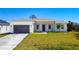 A charming single-Gathering home boasts a well-manicured lawn, a modern garage door, and stone accents at 159 Antilla Dr, Rotonda West, FL 33947