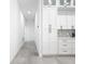 Hallway view of pantry with shaker style white cabinets and tiled backsplash at 159 Antilla Dr, Rotonda West, FL 33947