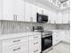 Bright kitchen features white cabinets, quartz countertops, and modern stainless steel appliances at 159 Antilla Dr, Rotonda West, FL 33947
