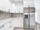 A well-designed kitchen features white cabinets, stainless steel refrigerator, and stylish backsplash at 159 Antilla Dr, Rotonda West, FL 33947
