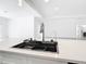 Contemporary kitchen island with sleek black sink, quartz countertops, and an open view at 159 Antilla Dr, Rotonda West, FL 33947