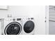 Modern, front-load washer and dryer set next to door to garage at 159 Antilla Dr, Rotonda West, FL 33947